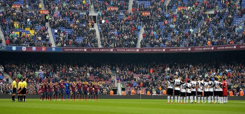 Barcelona, Valencia and Camp Nou fans observe a minute of silence for late former coach Luis Aragones before their match on February 1, 2014. Aragones, the coach of Spain's 2008 European Championship-winning side, died in Madrid at the age of 75. LLUIS GENE / AFP


