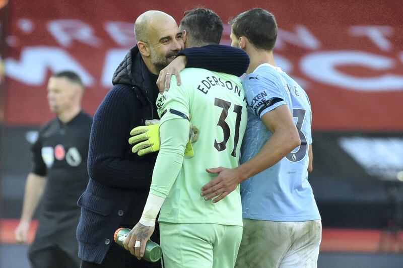 Manchester City's Spanish manager Pep Guardiola (L) reacts with Manchester City's Brazilian goalkeeper Ederson at the final whistle during the English Premier League football match between Sheffield United and Manchester City at Bramall Lane in Sheffield, northern England on October 31, 2020. (Photo by Rui Vieira / POOL / AFP) / RESTRICTED TO EDITORIAL USE. No use with unauthorized audio, video, data, fixture lists, club/league logos or 'live' services. Online in-match use limited to 120 images. An additional 40 images may be used in extra time. No video emulation. Social media in-match use limited to 120 images. An additional 40 images may be used in extra time. No use in betting publications, games or single club/league/player publications. / 