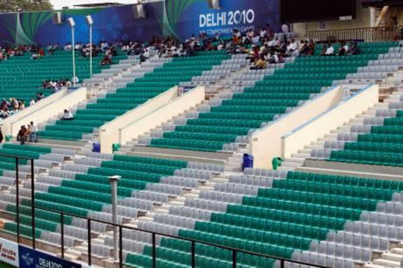 Spectators sit in the near-empty stands just before the start of the women's field hockey group match between Australia and Scotland at the Commonwealth Games in New Delhi October 9, 2010.   REUTERS/Danish Ismail (INDIA - Tags: SPORT FIELD HOCKEY) *** Local Caption ***  del42_GAMES_1009_11.JPG