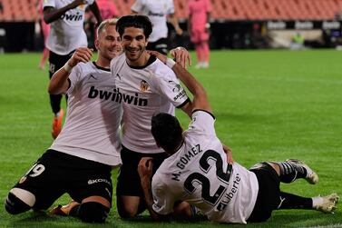 Valencia's Spanish midfielder Carlos Soler (C) celebrates with Uros Racic and Maxi Gomez after scoring against Real Madrid. AFP