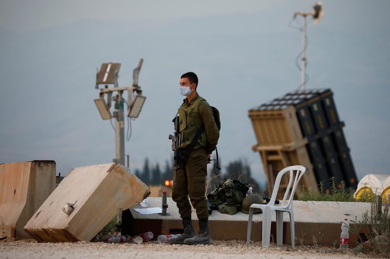 An Israeli soldier stands guard next to an Iron Dome anti-missile system. Reuters