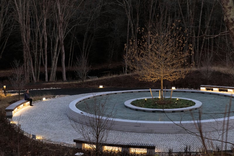 A visitor to the Sandy Hook Memorial sits on a bench at twilight. AP