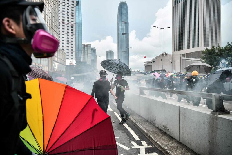 Protesters react after police fired tear near the government headquarters of Hong Kong.    AFP