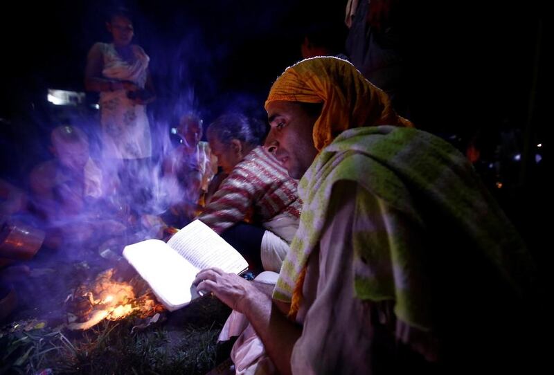 A Hindu priest recites prayers from a holy book while performing a ritual near the bank of Bagmati River during Kuse Aunse (Father’s Day) at Gokarna Temple in Kathmandu, Nepal. Hindus all over the country, whose fathers have passed away, come to the temple for worship, holy dips, and to present offerings on this occasion. Navesh Chitrakar / Reuters