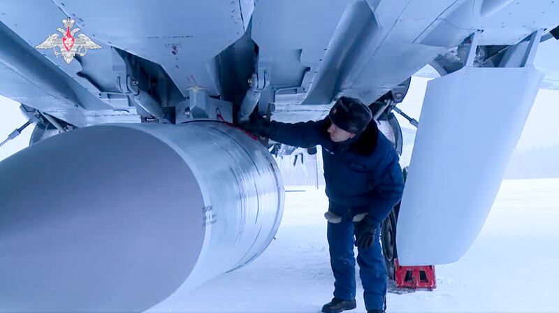 A Russian military technician checks a Kinzhal hypersonic cruise missile slung under the belly of a MiG-31. AP