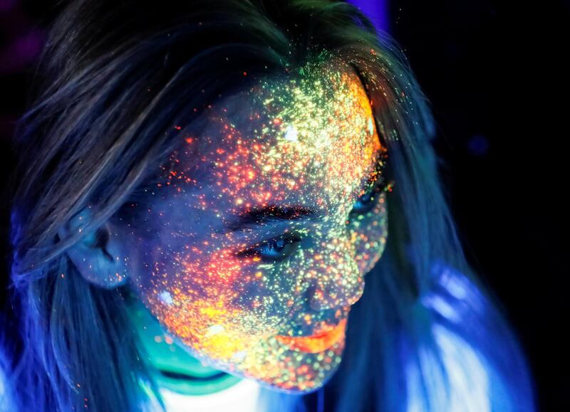 A participant with her face decorated with fluorescent paint smiles before the YARKOcross Night Edition colour run race in Almaty, Kazakhstan. Reuters