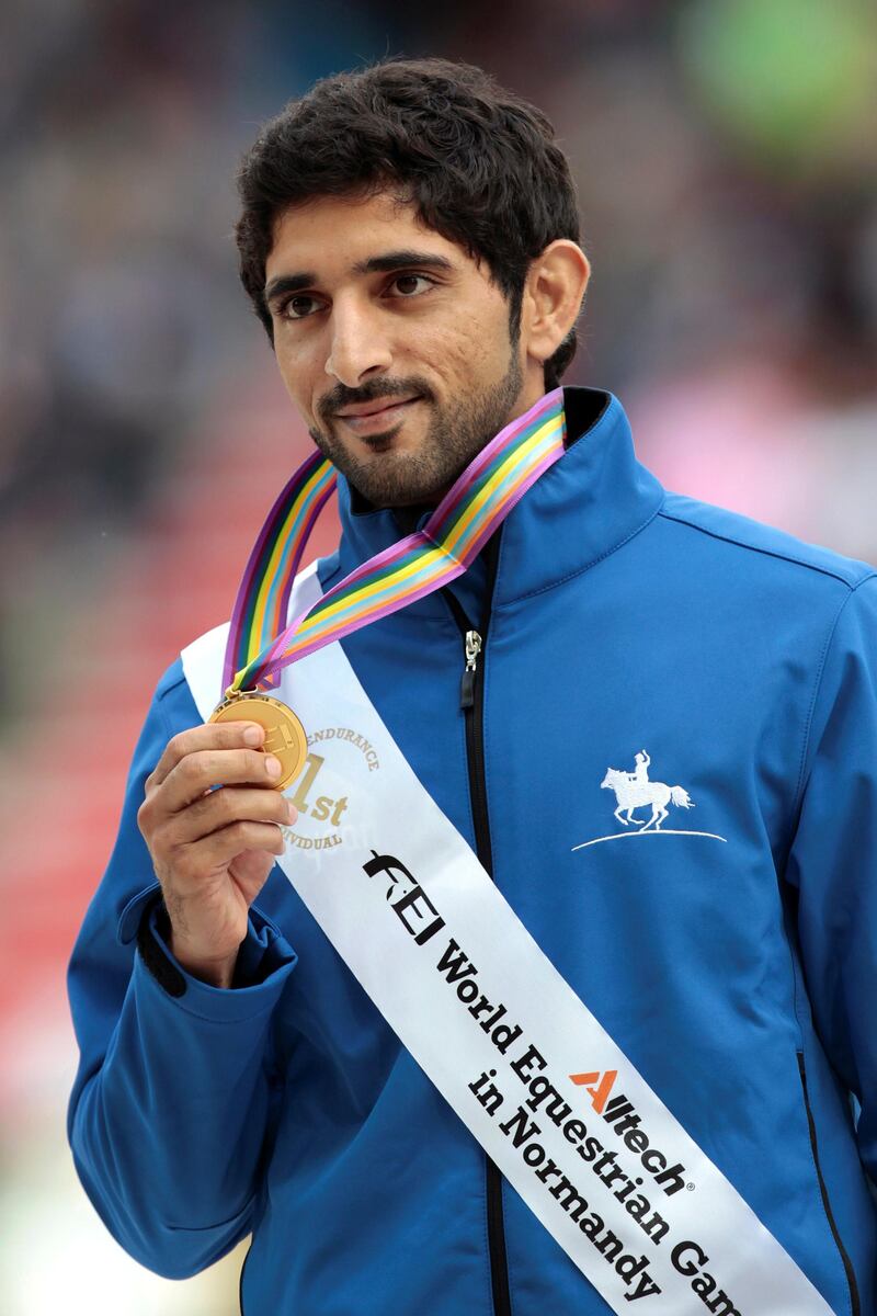 Gold medalist United Arab Emirate Sheikh Hamdan bin Mohamed al Maktoum 1er celebrates on August 29, 2014 on the podium during the medal ceremony of the Individual Endurance competition of the 2014 FEI World Equestrian Games, in the northwestern French city of Caen. AFP PHOTO /CHARLY TRIBALLEAU (Photo by CHARLY TRIBALLEAU / AFP)