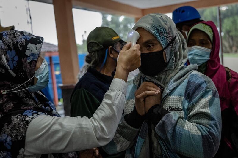 A health officer checks a woman temperature body as they evacuated villagers to a temporary evacuation center after mount Merapi spew pyroclastic smoke in Yogyakarta, Indonesia. Getty Images