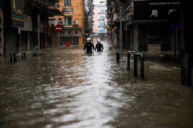TOPSHOT - Rescue workers make their way through floodwaters during a rescue operation during Super Typhoon Mangkhut in Macau on September 16, 2018. / AFP / ISAAC LAWRENCE

