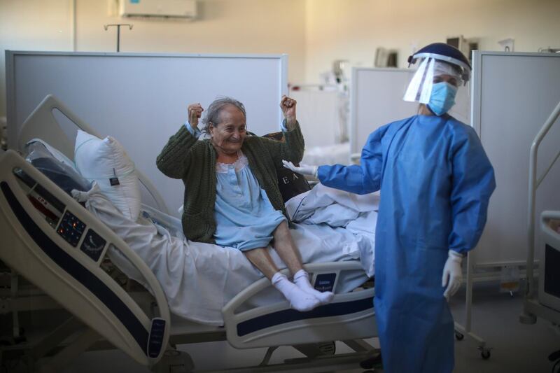 Blanca Ortiz, 84, celebrates after learning from nurses that she will be dismissed from the Eurnekian Ezeiza Hospital, on the outskirts of Buenos Aires, Argentina several weeks after being admitted with Covid-19. AP Photo