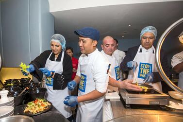 Mariam Al Mehairi, Minister of State for Food Security, helps cook a meal using leftover food, at the World Food Programme Stop the Waste Campaign last week. Leslie Pableo for The National