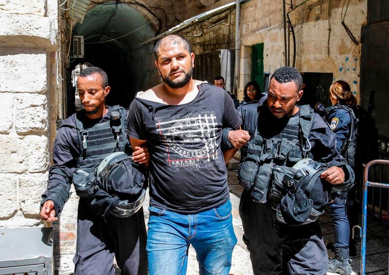 Members of the Israeli security forces take into custody a Palestinian protester who was arrested during clashes at the Aqsa mosque compound in the Old City of Jerusalem on July 27, 2018.  / AFP / Ahmad GHARABLI
