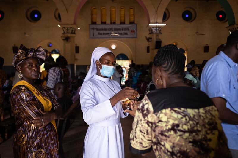 A nun hands out communion to a worshipper at a cathedral in the capital, Ouagadougou, after a massacre in Burkina Faso by extremists. AFP