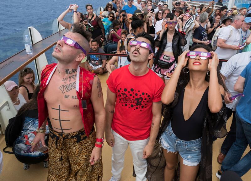 Cole Whittle, left, and Joe Jonas of multi-platinum-selling band DNCE, joined actress Shay Mitchell to celebrate the Great American Eclipse aboard Royal Caribbean's Oasis of the Seas. The ship set sail along the path of totality, offering guests a once-in-a-lifetime view of the epic celestial event. Charles Sykes / Invision for Royal Caribbean International / AP Images
