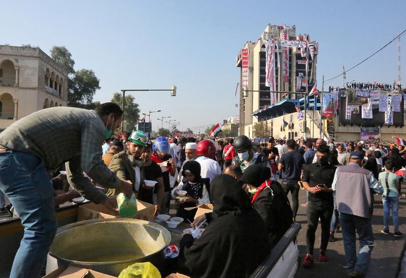 Iraqis share a meal during an anti-government demonstration in Tahrir square. AFP