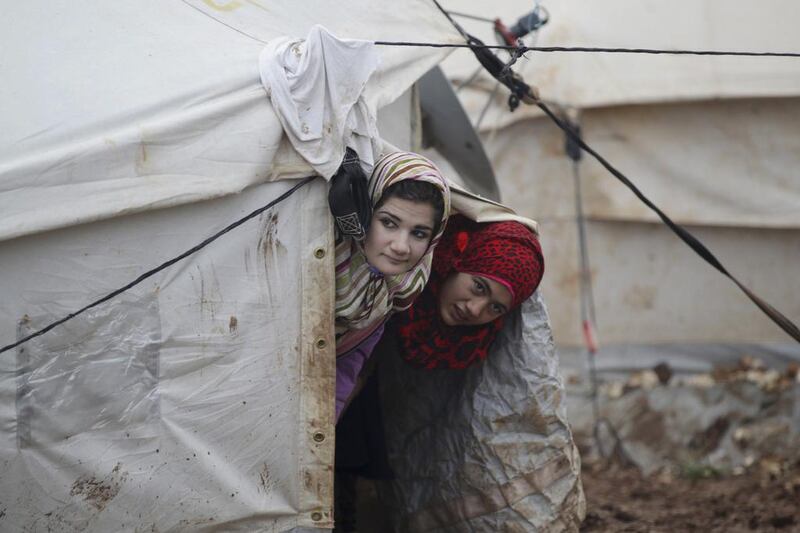 Girls look at the storm from their tent inside Al Karameh refugee camp on the Syrian-Turkish border in Idlib. Khalil Ashawi / Reuters