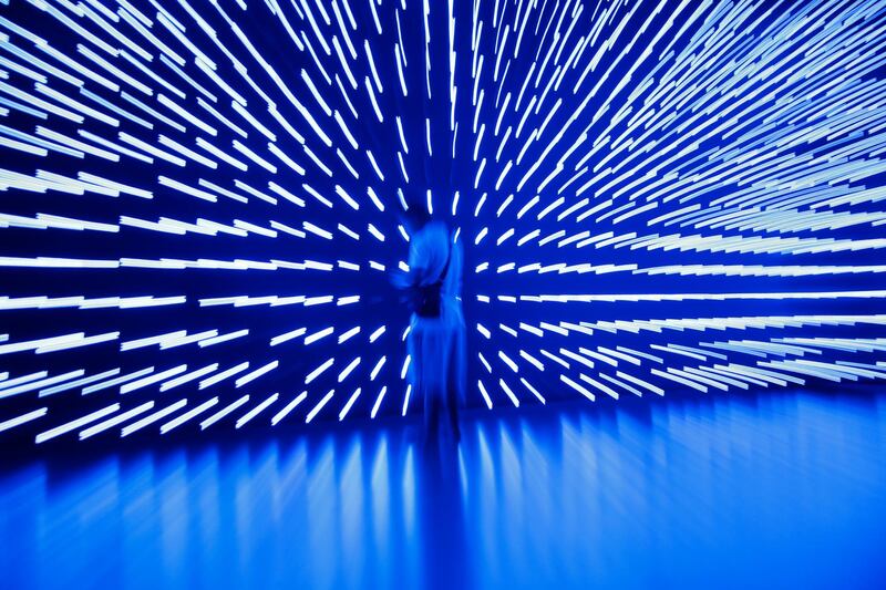 A visitor stands in front of an illuminated wall installation titled 'Mega Death' by Japanese artist Tatsua Miyajima, displayed as part of an exhibition entitled Minimalism: Space. Light. Object, at the National Gallery in Singapore. EPA