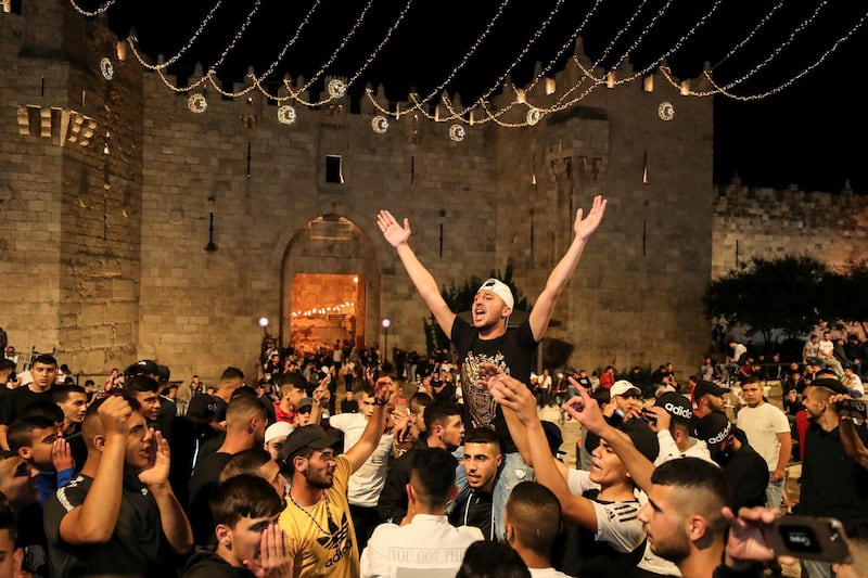 Palestinians celebrate outside Damascus Gate after barriers that were put up by Israeli police are removed, allowing them to access the main square on April 25, 2021. Reuters