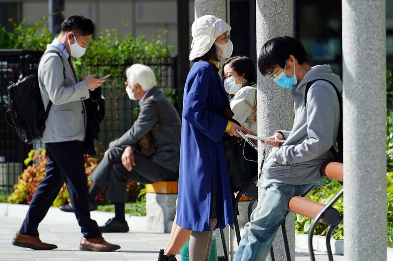 People in face masks are seen at a park, in Tokyo. AP Photo