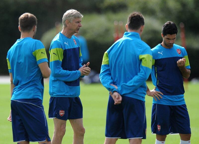 Arsenal manager Arsene Wenger, second right, runs a team training session on Monday. Olly Greenwood / AFP / August 18, 2014