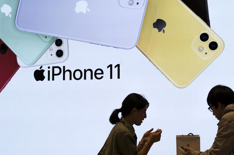 An employee helps a customer as he purchases an iPhone11 at the Apple Marunouchi store in Tokyo, Japan. Getty Images