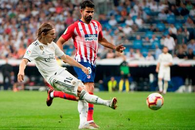 Real Madrid's Croatian midfielder Luka Modric (L) vies with Atletico Madrid's Spanish forward Diego Costa during the Spanish league football match between Real Madrid CF and Club Atletico de Madrid at the Santiago Bernabeu stadium in Madrid on September 29, 2018. / AFP / CURTO DE LA TORRE
