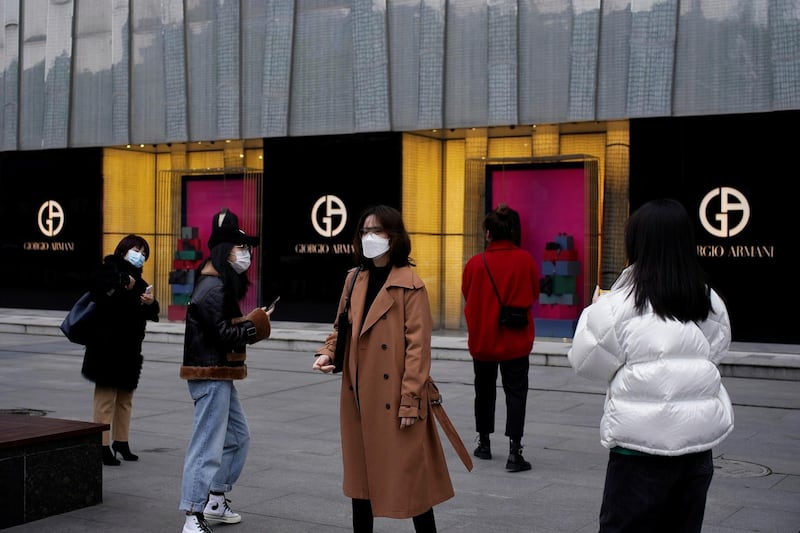 People wearing face masks are seen outside a Giorgio Armani store at a shopping mall in Wuhan, Hubei province, the epicentre of China's coronavirus disease (COVID-19) outbreak. REUTERS
