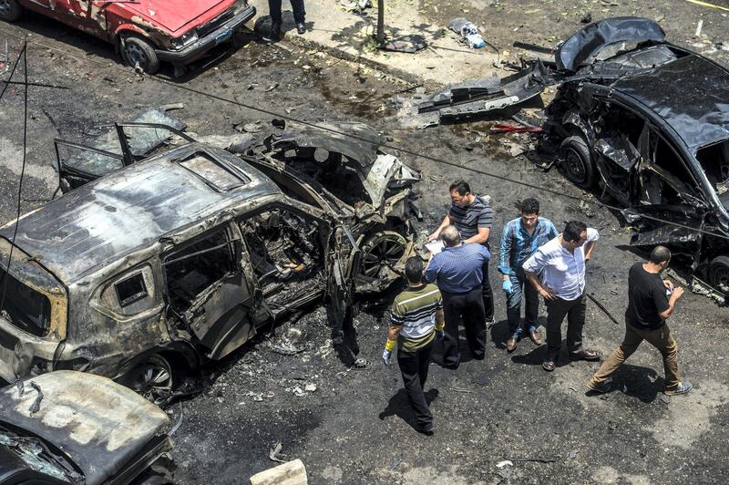 Forensic detectives gather at the site of a bomb that targeted the convoy of the Egyptian state prosecutor, Hisham Barakat, in the capital Cairo on June 29, 2015. Egypt's state prosecutor was wounded when a powerful bomb hit his convoy in the capital, officials said, after jihadists urged attacks on the judiciary to punish a crackdown on Islamists. AFP PHOTO / KHALED DESOUKI (Photo by KHALED DESOUKI / AFP)