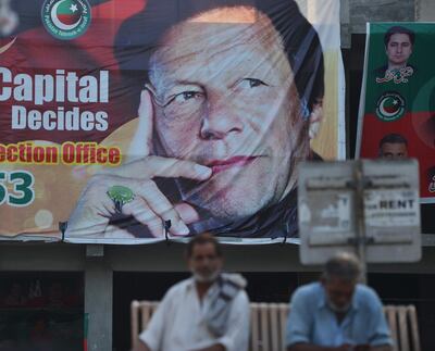 Pakistani men sit near a poster of Pakistan's cricketer-turned politician and head of the Pakistan Tehreek-e-Insaf (Movement for Justice) party Imran Khan, in Islamabad on July 30, 2018.
Pakistan's World Cup cricket hero Imran Khan is set to become prime minister of the nuclear-armed nation of 207 million, with an economy inching toward crisis and perennial conflict on its borders. Running the country will take considerable statecraft from Khan's relatively inexperienced party. He brings charisma, international name recognition and a sizeable election victory, though not enough to form a majority government.
 / AFP PHOTO / AAMIR QURESHI