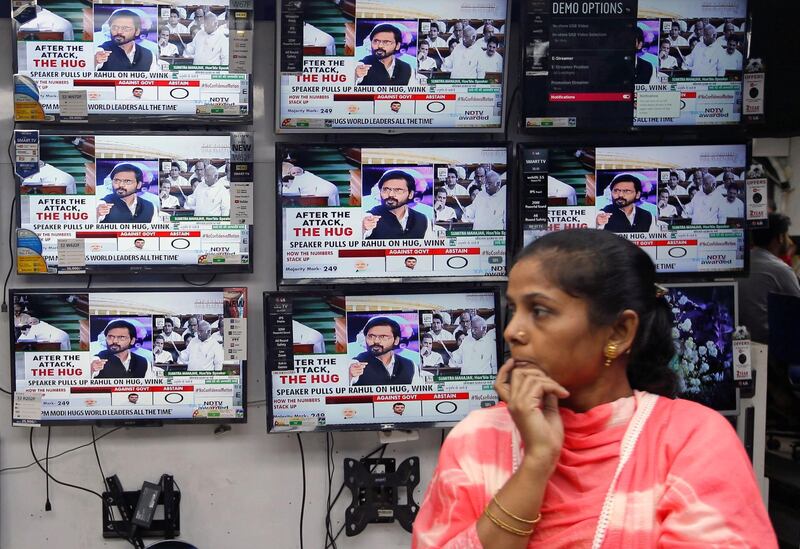 A woman watches a news television debate about Indian opposition leader Rahul Gandhi's hug to Prime Minister Narendra Modi during a no-confidence motion in parliament, at an electronics store in Kolkata, India, July 20, 2018. REUTERS/Rupak De Chowdhuri
