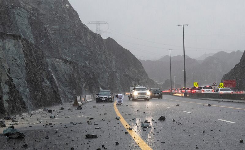 A man clears rocks from the road.  Ruel Pableo for The National