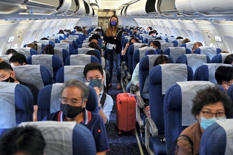 This photo taken on August 16, 2020 shows passengers wearing face masks as a preventive measure against the COVID-19 coronavirus waiting to disembark from a Bangkok Airways domestic flight on arrival at Koh Samui airport in Koh Samui, southern Thailand. (Photo by Romeo GACAD / AFP)