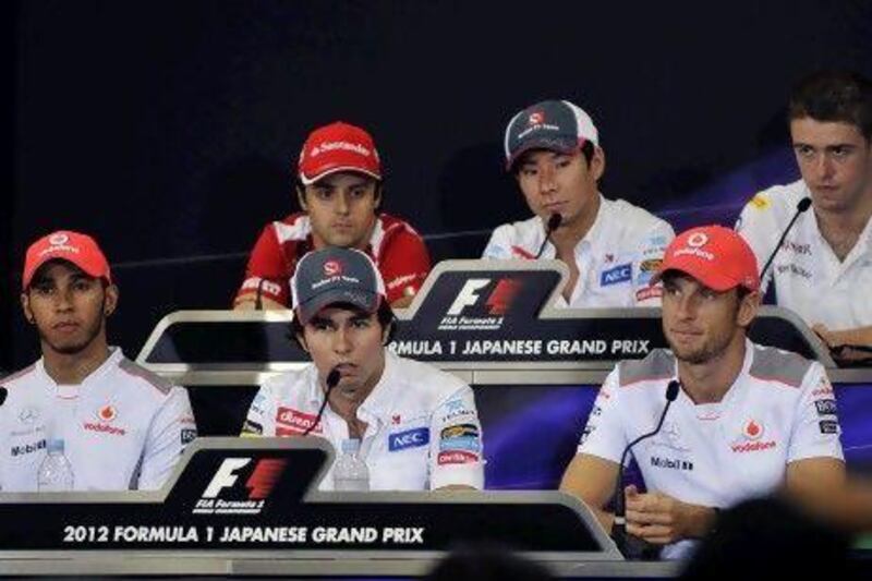 Sergio Perez, front centre, sits between Lewis Hamilton and Jenson Button.