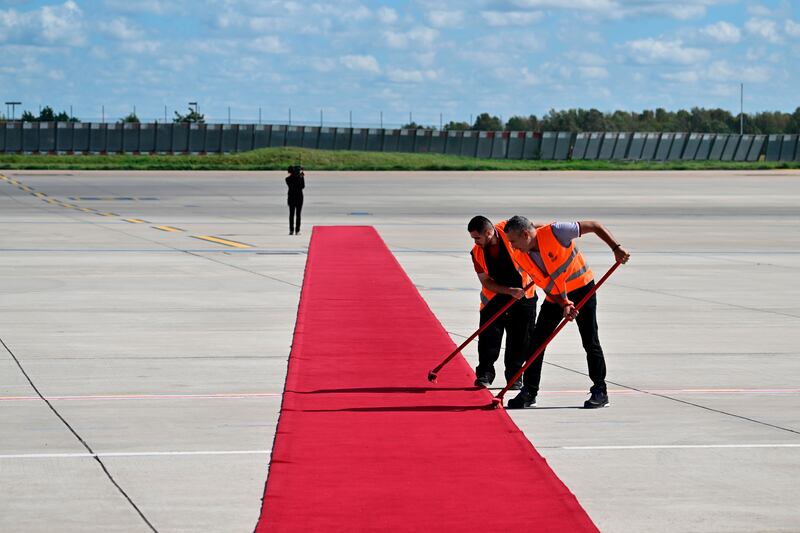 Workers clean the red carpet at Orly Airport. AP