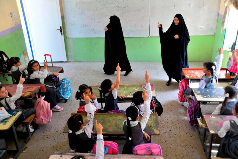 Pupils attend a class on their first day of school in Najaf, central Iraq. AFP