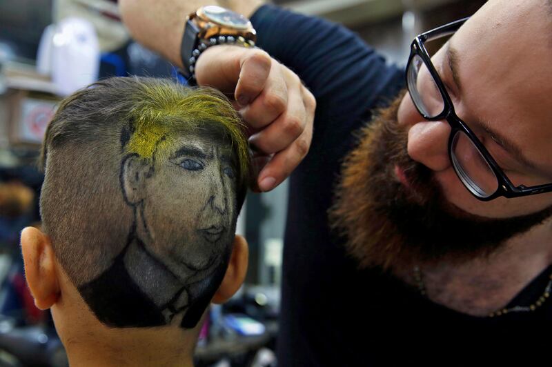 
                  In this Friday, July 14, 2017 photo, Muhannad Khaled Omar, right, prepares an image of U.S. President Donald Trump on the back of a customer's head at his barber shop in Burj al-Barajneh, southern Beirut, Lebanon. In a city full of hair stylists, Omar stands out. He is a 26 year-old Palestinian-Syrian hair stylist known for shaving celebrity portraits into clients’ hair. (AP Photo/Bilal Hussein)
               