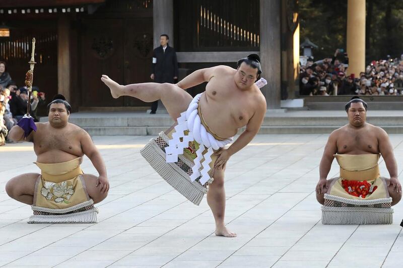Newly promoted sumo grand champion Kisenosato performs his ring entry form at the Meiji Shrine in Tokyo on January 27, 2017. Kisenosato is the first Japanese wrestler to earn the coveted rank of “yokozuna,” grand champion, since 1998. Accompanying Kisenosato are sward-holder Takayasu, left, and dew-sweeper Shohozan, right. Eugene Hoshiko / Associated Press