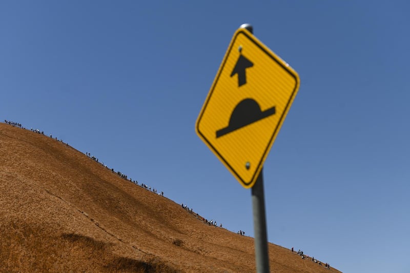 Tourists climb Uluru. EPA