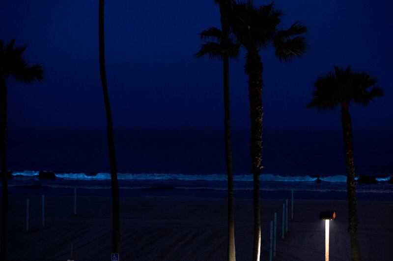 The bioluminescent waves crash on the sand shining with a blue glow at Manhattan Beach,  California.  Bioluminescence is a phenomenon caused by certain kinds of phytoplankton associated with red tide that by night generate a pulse of blue light as the waves crash. / AFP / VALERIE MACON