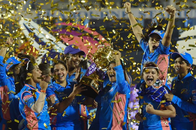 Mumbai Indians players pose with the trophy after winning the 2023 Women's Premier League following their win over Delhi Capitals at the Brabourne Stadium in Mumbai on Sunday, March 26, 2023. AFP