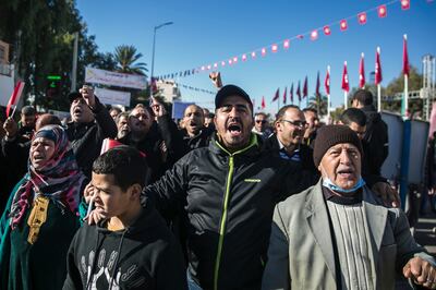 People shout slogans as they attend a protest on the anniversary of the Tunisian revolution. AP