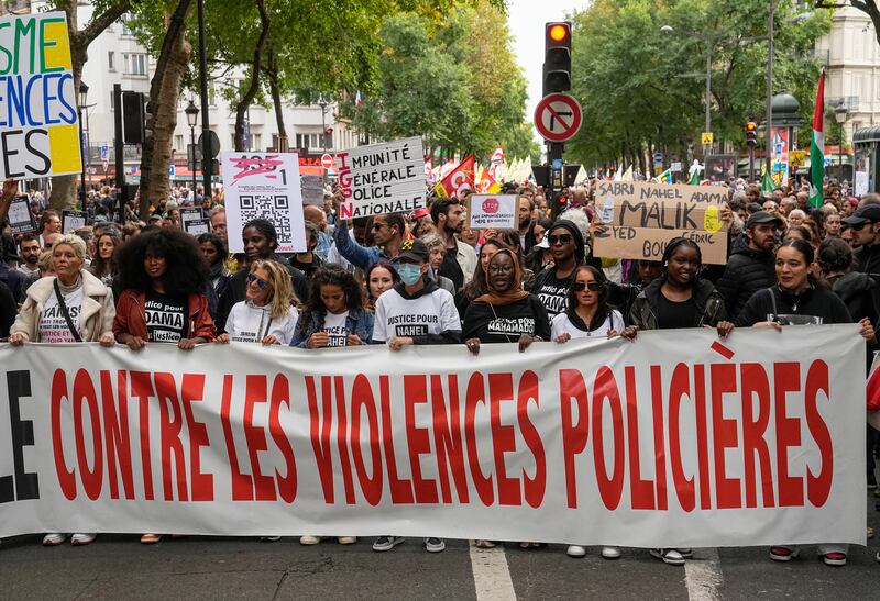 People march with a banner that reads, "against police violence," in Paris, on September 23. AP Photo