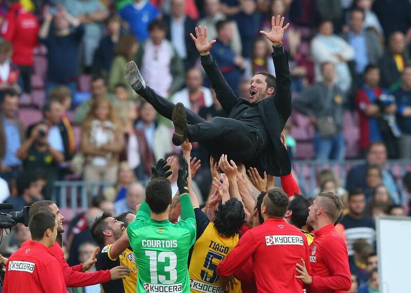 Atletico Madrid manager Diego Simeone is thrown into the air by his players following their draw with Barcelona to win the La Liga title. Alex Livesey / Getty Images / May 17, 2014