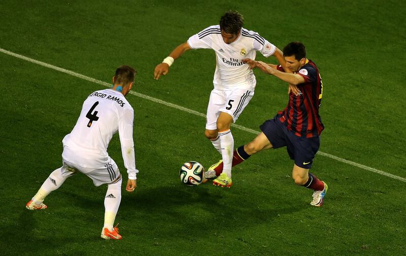 Barcelona's Argentinian forward Lionel Messi (R) vies with Real Madrid's defender Sergio Ramos (L) and Real Madrid's Portuguese defender Fabio Coentrao during the Spanish Copa del Rey (King's Cup) final "Clasico" football match FC Barcelona vs Real Madrid CF at the Mestalla stadium in Valencia on April 16, 2014.   AFP PHOTO/ JOSE JORDAN (Photo by JOSE JORDAN / AFP)