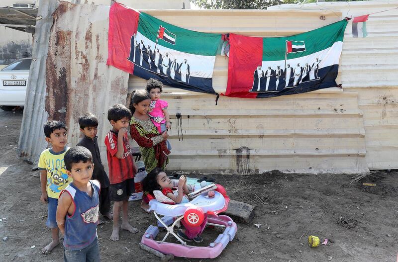 RAS AL KHAIMAH , UNITED ARAB EMIRATES , DEC 02  – 2017 :- Children with the UAE flag outside their home on the National Day in Ras Al Khaimah. (Pawan Singh / The National) Story by Anna Zacharias