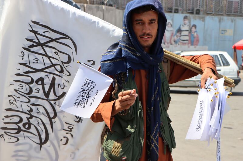 An Afghan man sells Taliban flags in Kabul. EPA