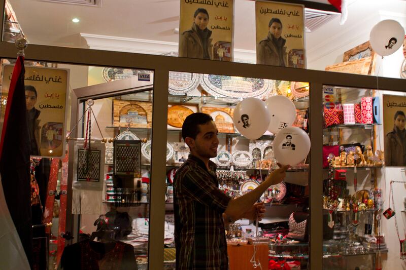 A shop worker holds a ballon with a picture of Palestinian singer Mohammed Assaf  at the Movenpeak Hotel in Gaza City where hundreds of supporters gathered to watch Friday night's 'Arab Idol' song contest held in Beirut ,Lebanon, June 21,2013.  Mohammed Assaf was declared the winner of the  regional 'Arab Idol' singing contest held in Beirut , Lebanon June 22,2013.Thousands of Palestinians in Gaza and the West Bank took to the streets to celebrate his victory. (Photo by Heidi Levine/Sipa Press). *** Local Caption ***  IMG_9678.jpg