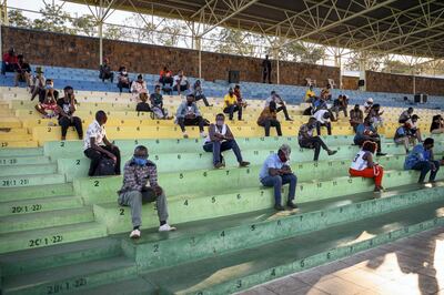 People who did not respect the measures to prevent the spread of the COVID-19 (novel coronavirus) pandemic, such as the correct wearing of masks in public places, are forced to sit and listen the prevention speeches for a few hours in Nyamirambo stadium in Kigali, Rwanda on August 3, 2020. (Photo by STR / AFP)