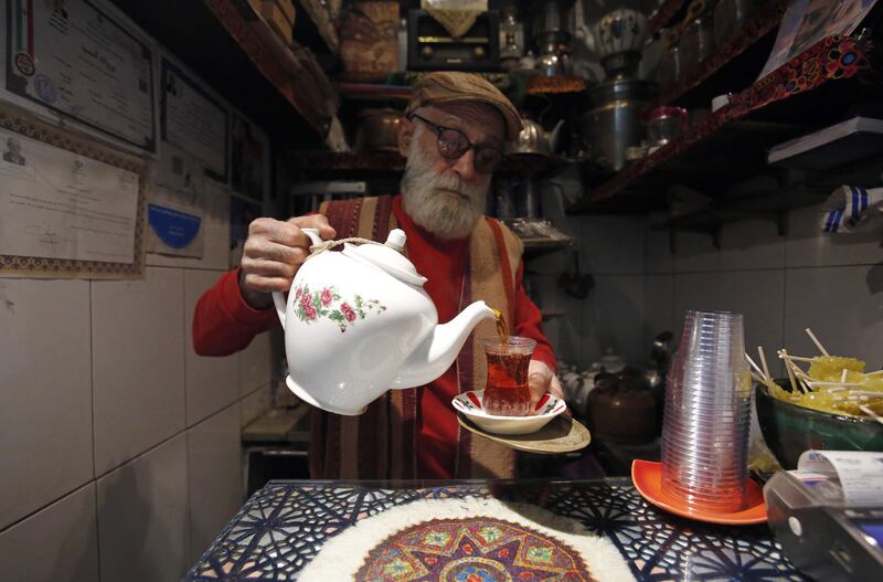 Kazem Mabhutian, 65, serves tea to customers in his Haj Ali Darvish Teahouse in the Old Grand Bazaar in Tehran, Iran, 01 March 2023.  At two square meters it is considered one of the smallest in the world.  Kazeem took over the business from his father, who bought the teahouse in 1962 from its original owner.  Established in 1918, it is listed on the National Cultural Heritage List of Iran.   EPA / ABEDIN TAHERKENAREH