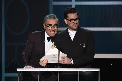 Canadian actors Eugene Levy (L) and Dan Levy present an award during the 26th Annual Screen Actors Guild Awards show at the Shrine Auditorium in Los Angeles on January 19, 2020. / AFP / Robyn Beck
